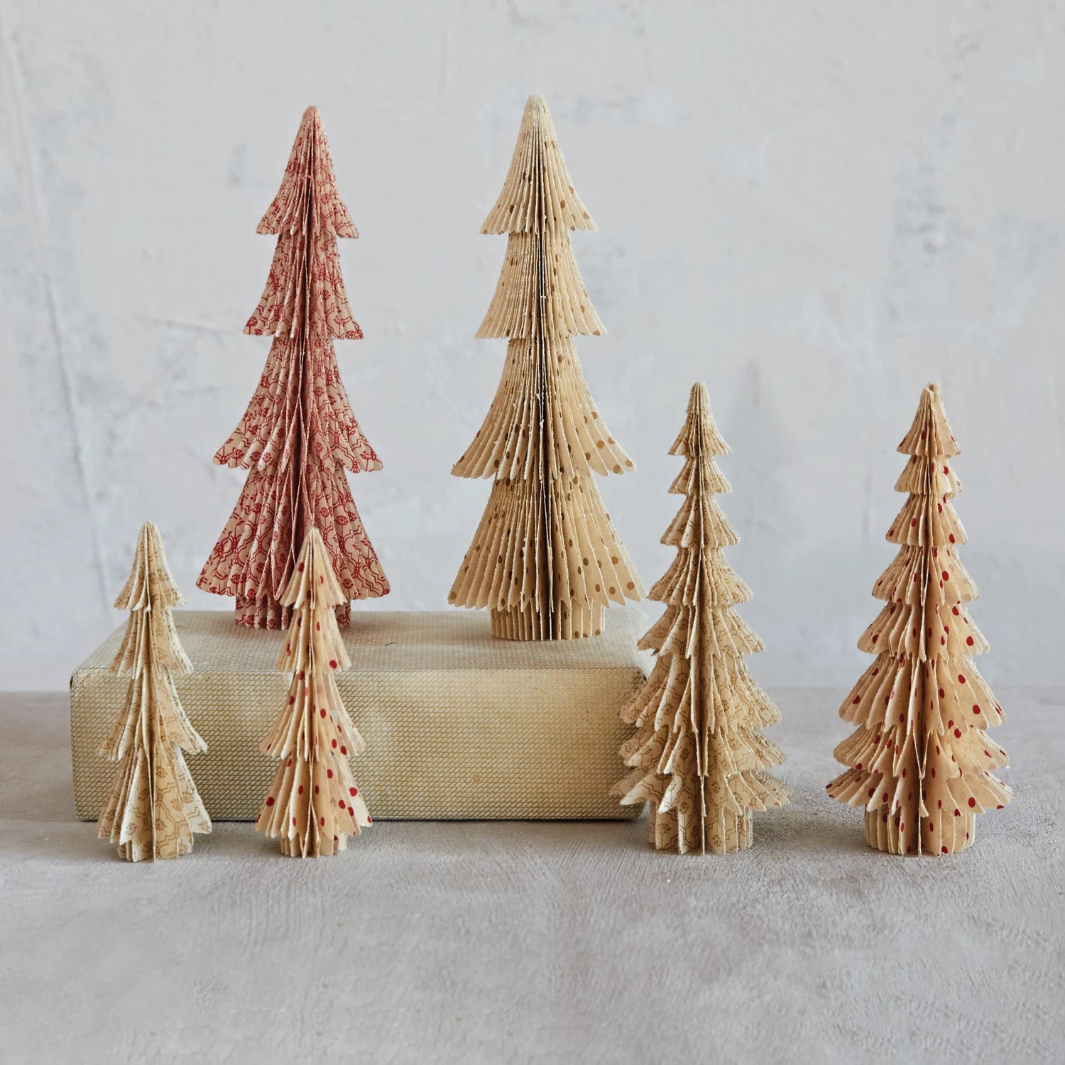 Staggered coordinating sets of recycled seven inch paper trees in either glittered gold or red polka dots. 