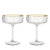 Two empty meridian fluted coupe glasses with gold rims.