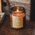 Wild fig and citrus amber glass candle with flame. 