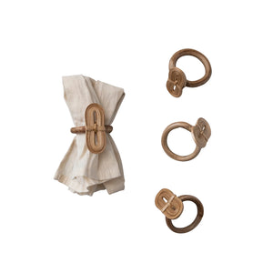 set of four natural handmade bamboo napkin rings displayed on white linen cloth. 
