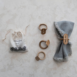 set of four natural handmade bamboo napkin rings displayed on linen cloth. 