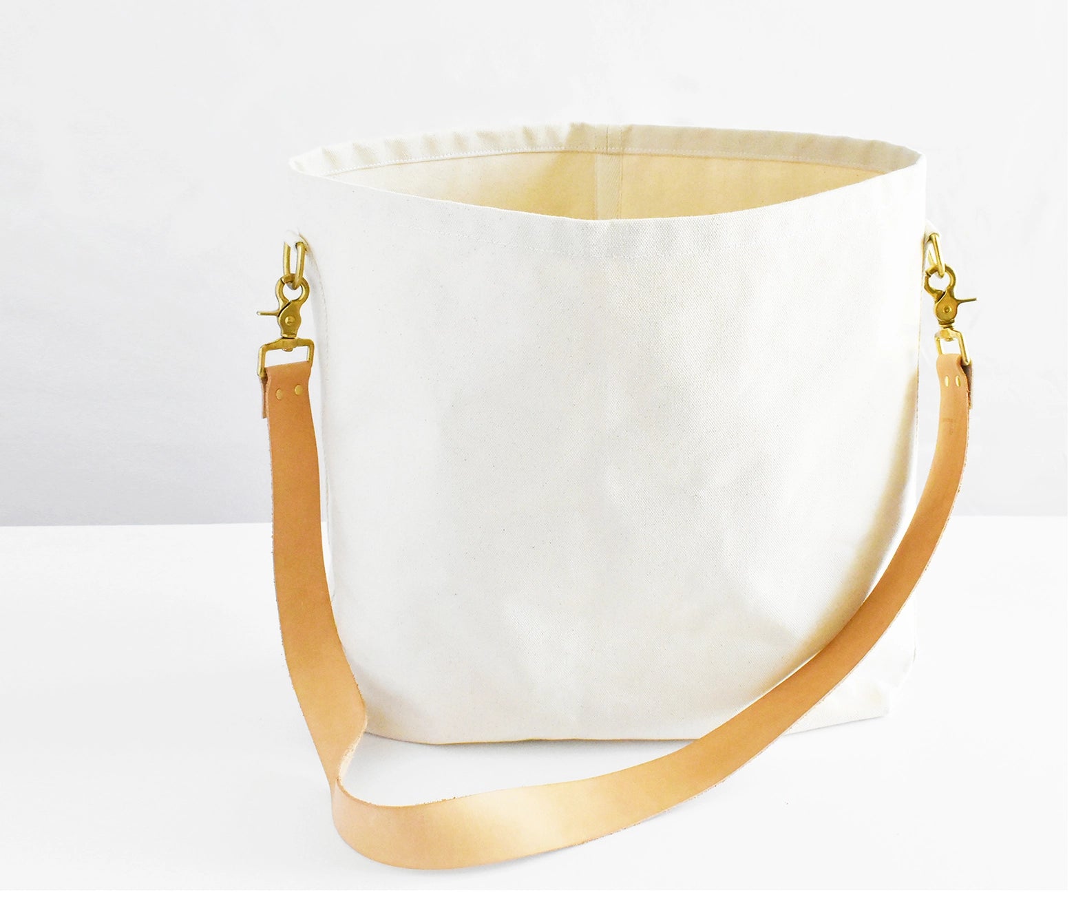 Cotton canvas tote crossbody bag with genuine tan leather straps. 