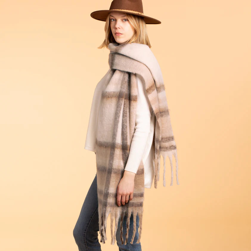 Woman showcasing a plaid cream cozy scarf, extra long with a fringe.