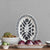 Oval stoneware hand painted black and white floral platter displayed standing up. 