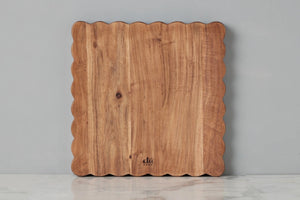 Individual acacia wood scalloped cutting board displayed face up. Hand made in India. 