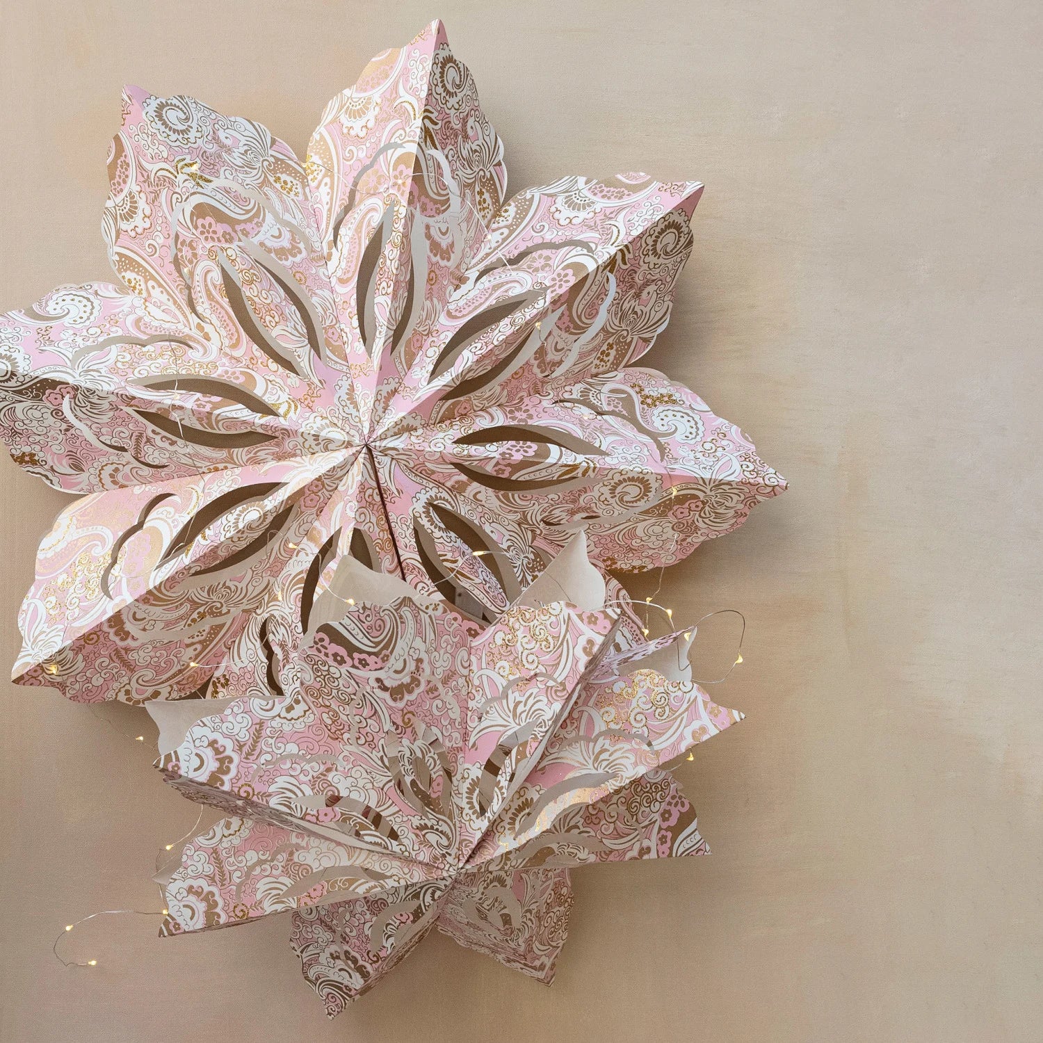 Retro pink and gold hanging [a[er snowflake with light. Eighteen inches in diameter, battery included. 