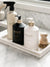 L'AVANT white marble tray with a brass line around the edge displaying hand soap, dish soap, counter spray, and wood scrubber.