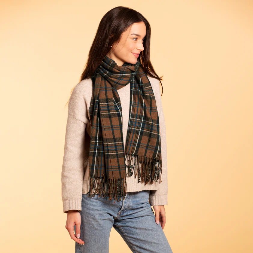 Woman showcasing a brown and blue plaid scarf with a braided fringe.