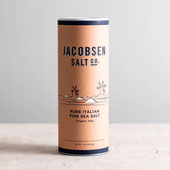 Cannister of Jacobsen Trapani Italian fine sea salt on white stone counter.